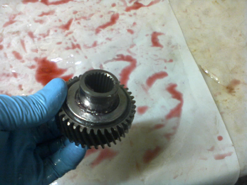 So now we take this rear sun gear (after cleaning it, of course) and place the flat roller bearing around the snout. The bearing is all greased up with petroleum jelly, which makes a great assembly lube for transmissions.